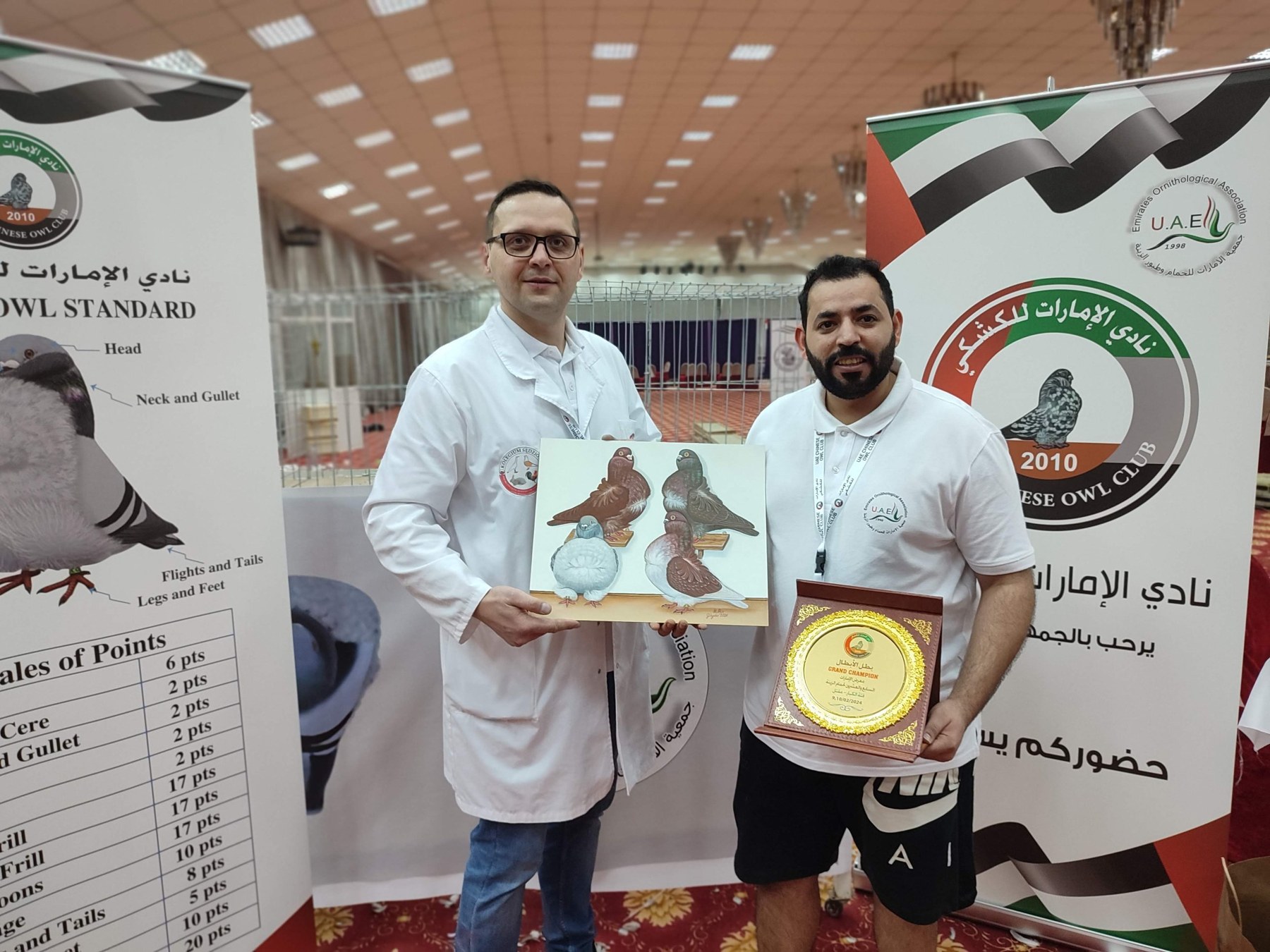 Karol Sarnecki z pamiątkową grafiką chińskich gołębi i organizator wystawy z pucharem Grand Champion, Zjednoczone Emiraty Arabskie